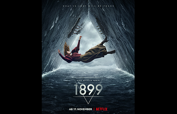 A person floats horizontally in a dark, triangular opening above a stormy ocean.