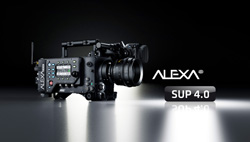 A professional black cinema camera with a large lens sits on a reflective surface next to ALEXA SUP 4.0 text.