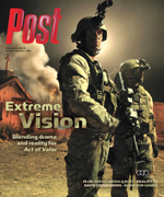 Two soldiers in tactical gear stand in front of a burning building with smoke in the background.