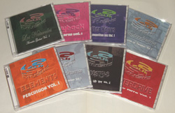 Eight music CDs with various colorful covers arranged in two rows on a white background.