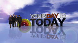 Four people stand beside large text reading 'YOUR DAY IS TODAY' against a blue sky with clouds.