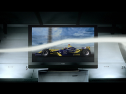 A television screen showing a yellow and blue racing car with a white light streak across the frame.