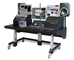 A professional audio workstation with multiple monitors, mixing consoles, and studio monitors on a rolling desk.