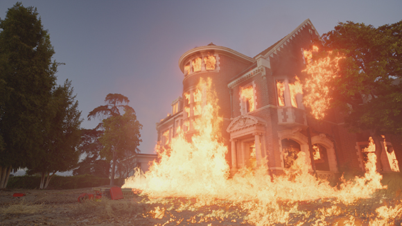 A large brick mansion with bright orange flames erupting from its windows and spreading across the ground.