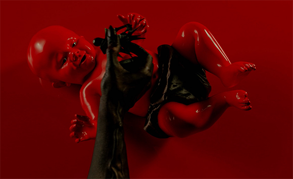 A glossy red baby figure lies on a red background while a black hand reaches toward it.