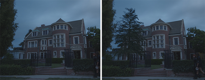 A large brick house with multiple gables and a turret under a dark, cloudy sky.