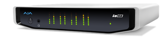 A white AJA io4K device with a black front panel displaying green and orange LED level meters.