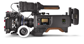 A professional cinema camera rig with a large lens, monitor, and wooden handles against a white background.