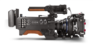 Side view of a black CION digital cinema camera with a large lens and various control ports.