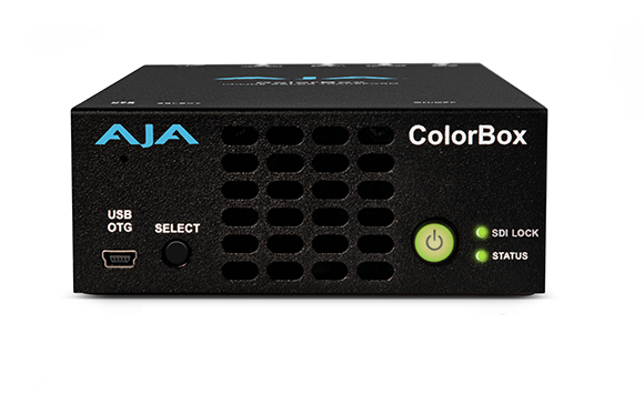 A black AJA ColorBox device with a power button, USB OTG port, and status lights.