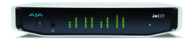 A white and black AJA io4K audio interface with green and orange LED level meters.