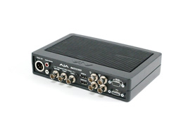 A black AJA video converter with various input and output ports on the front panel.
