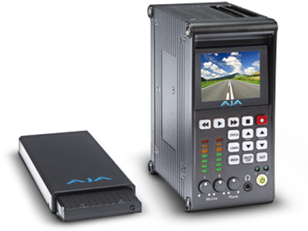 A black AJA video playback device with a screen and buttons next to a small black module.