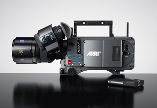 A black ARRI ALEXA Mini cinema camera with a large lens and a small accessory on a dark reflective surface.