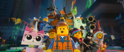 A large group of colorful LEGO minifigures standing together in a city setting.