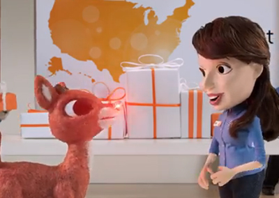 A red reindeer puppet looks up at a female puppet with brown hair and a blue shirt.