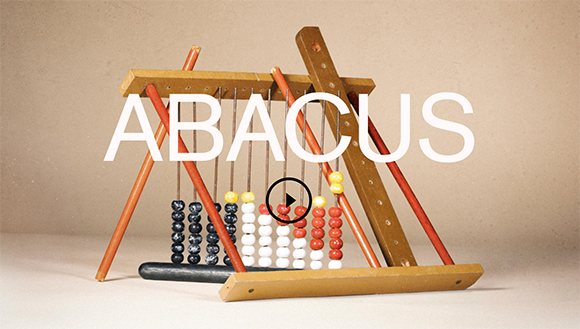 A wooden abacus with colorful beads on metal rods against a neutral background.