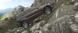A brown SUV climbs a steep, rocky mountain incline under a bright sky.