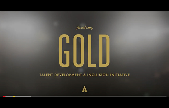 Gold text reading Academy GOLD and Talent Development & Inclusion Initiative on a dark, blurred background.