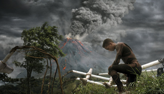 A person in a dark bodysuit crouches near debris with a large erupting volcano under a stormy sky.