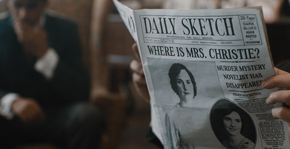 Hands holding a Daily Sketch newspaper featuring a headline about Mrs. Christie and a portrait of a woman.
