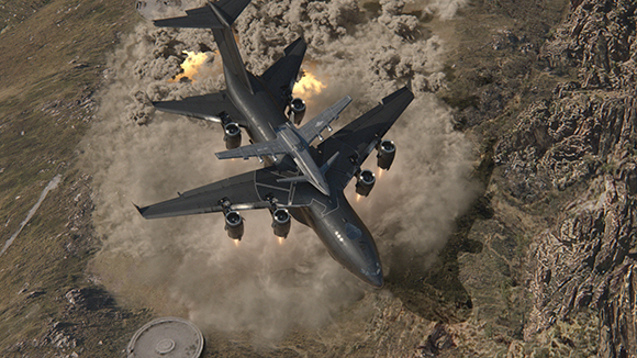 A dark military transport plane flies over a large plume of smoke and fire in a rocky canyon.