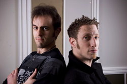 Two men standing back-to-back against a white door frame.
