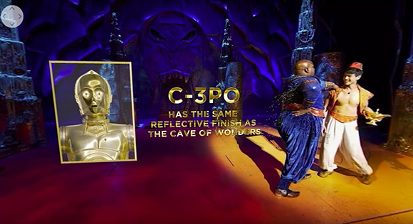 A split screen showing a gold droid on the left and two performers in a blue and gold cave set on the right.