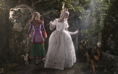 Two women in fantasy costumes walk through a stone garden with a large cat and a dog.