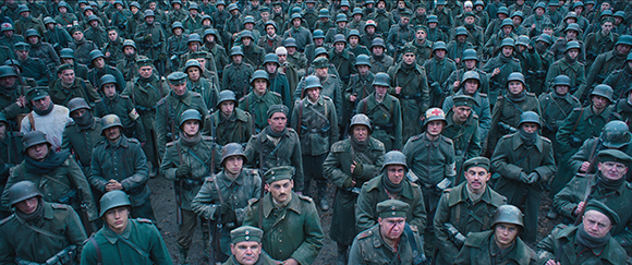 A dense crowd of soldiers in olive green uniforms standing in formation outdoors.