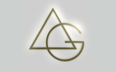 Gold metallic logo featuring an overlapping triangle and the letters A and G on a gray background.