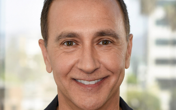 Close-up headshot of a middle-aged man with short brown hair and a warm smile.