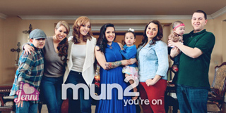 A group of adults and two children posing together in a living room.