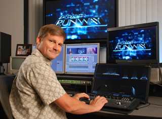 A man sits at a desk with several monitors displaying the Project Runway logo and video editing software.