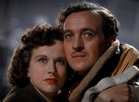 A close-up of a man and a woman leaning their heads together in a dramatic pose.