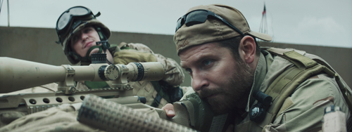 Two soldiers in military gear aiming a scoped rifle toward the distance.