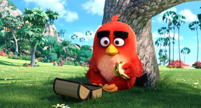 A red animated bird sits leaning against a large tree trunk, eating a sandwich in a grassy field.