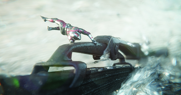 A small red and silver action figure lunges across a dark, textured ridge near splashing water.