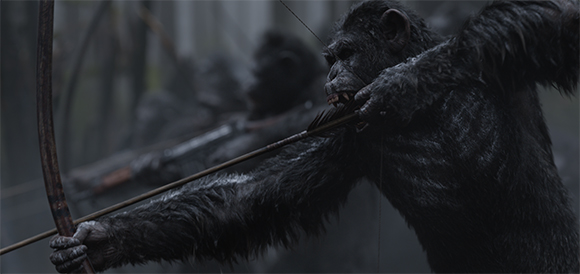 A chimpanzee holds a wooden bow and aims an arrow in a dark, misty forest.