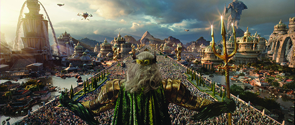 A figure in green and gold armor holds a trident, looking over a sprawling golden city filled with crowds.