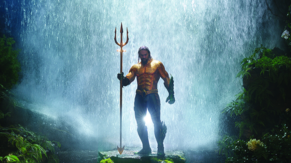 A man in gold scale armor stands holding a large golden trident before a misty waterfall.