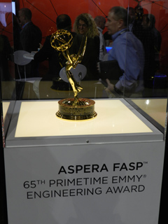 A gold Emmy award trophy sits on a display pedestal with text indicating it is the 65th Primetime Emmy Engineering Award.