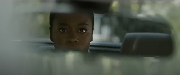 A person's eyes and forehead visible peering over the edge of a car dashboard.