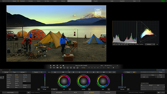 Video editing software showing a landscape of mountains, a lake, and colorful tents at a campsite.
