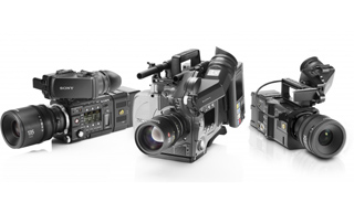 Three different professional black video cameras arranged on a white surface.