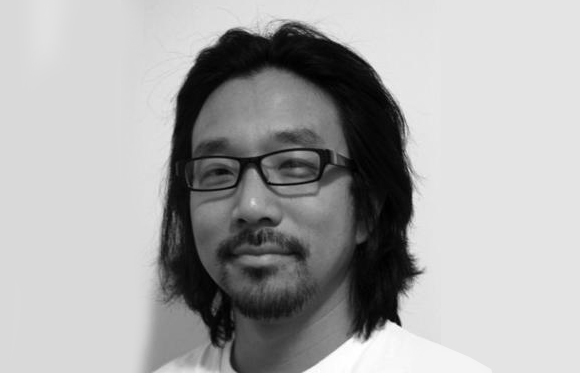 Black and white headshot of a man with dark hair, glasses, and a goatee.