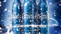 Four condensation-covered blue Bud Light bottles amidst a splash of water droplets against a blue background.