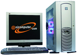 A silver computer tower next to a monitor displaying a website logo and a keyboard.