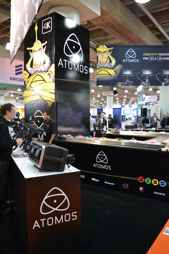 An Atomos exhibition booth featuring large brand graphics, monitors, and video equipment at a trade show.