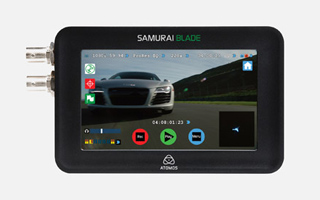 A black Atomos Samurai Blade device displaying a video of a silver car on its screen.